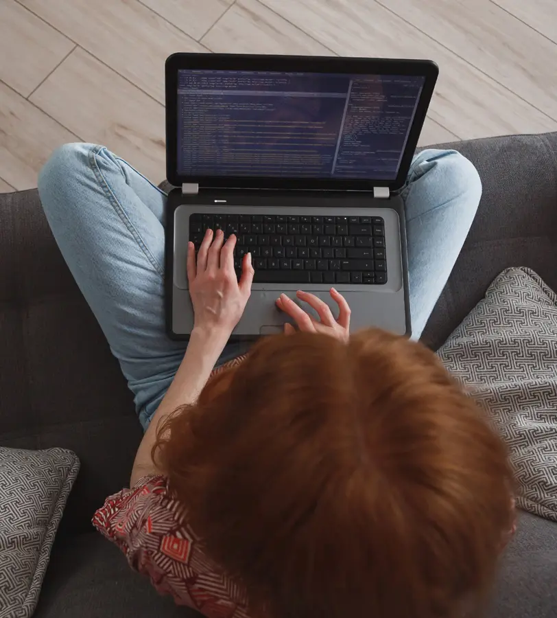 Building a Remote Work Security Plan | Chuck's Cyber Wall | Building a Remote Work Security Plan | Chuck's Cyber Wall | Remote Work Security Plan for small businesses image of woman typing code into a laptop at home.