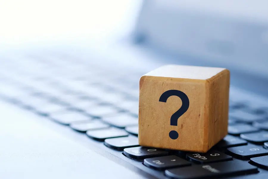 Overcoming Technology Barriers | Chuck's Cyber Wall | Overcoming Technology Barriers | Chuck's Cyber Wall | Overcoming Technology Barriers - Chuck's Cyber Wall, image of a question mark on a wooden block sitting on a laptop.