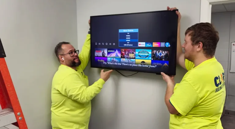 CLARK Provides Specialized IT Support for Construction | CLARK Provides Specialized IT Support for Construction | Two Clark technicians mounting a large TV monitor.