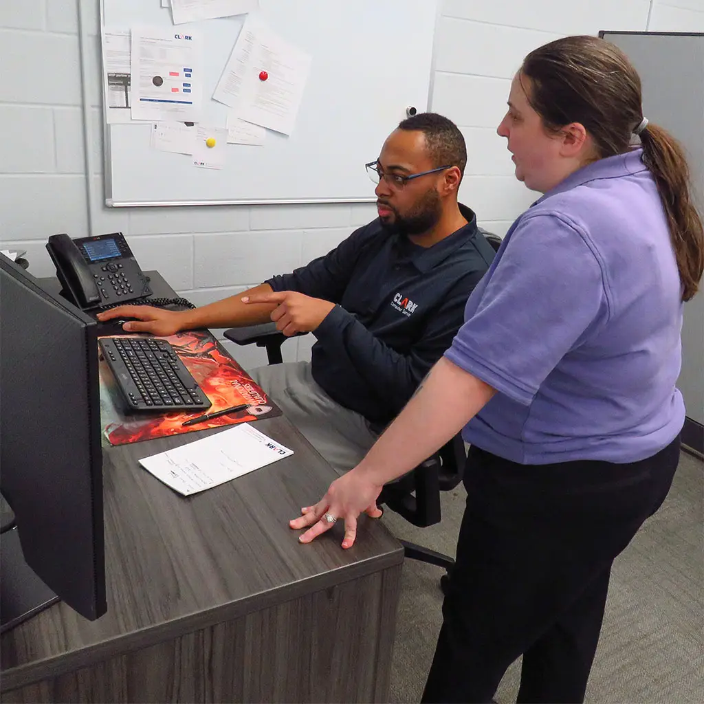 Public Institution IT Services | Secure & Reliable Solutions | Two Clark Computer Services technicians working together at a desk to help a public institution resolve an IT problem